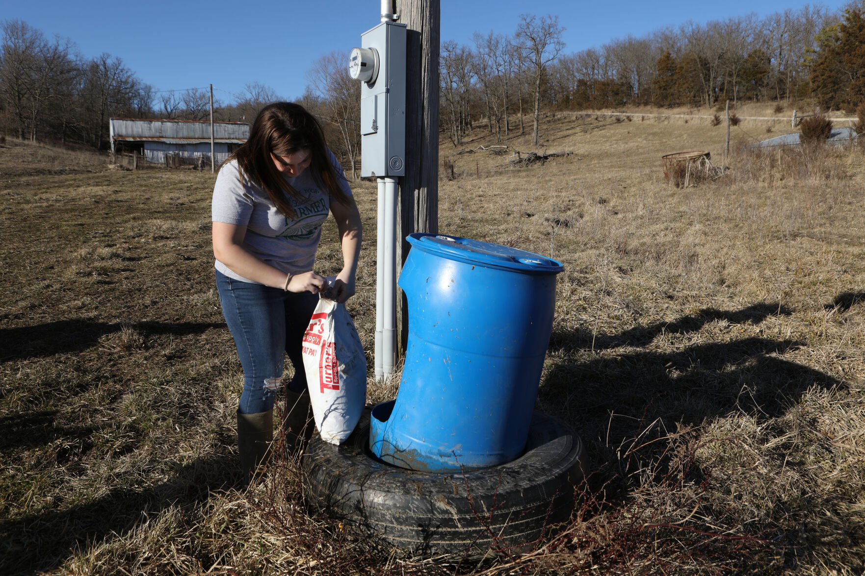 Katelyn Horstmann pours feed
